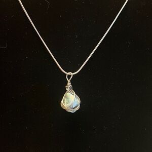 Handcrafted wire wrapped stone on an 18inch silver tone necklace.